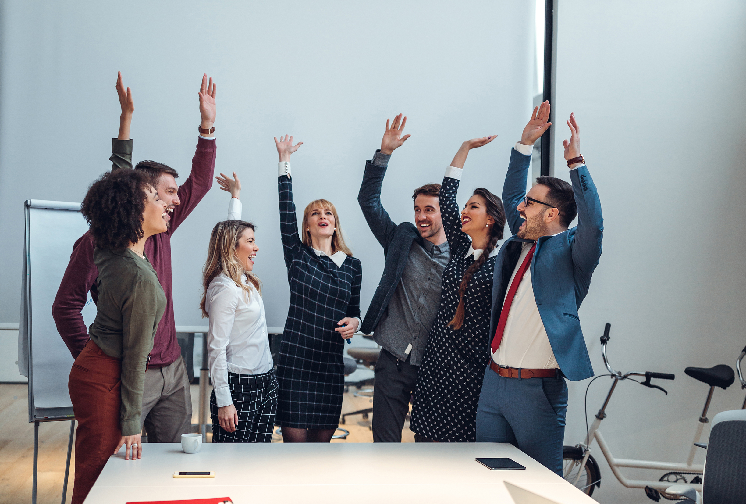 Celebrating a successful meeting Vertical shot of a group of coworkers cheering in an office